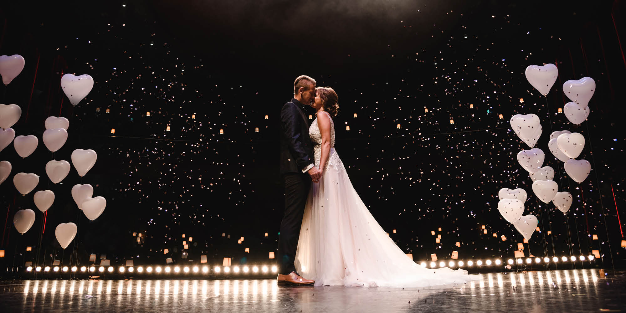 Brautpaar küsst sich auf der Bühne der Hochzeitslocation Bonn